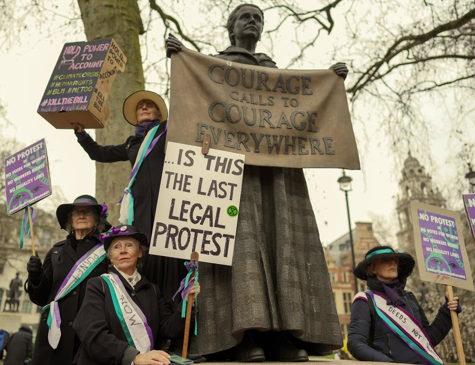 Protesters dressed as suffragettes holding placards including ‘Is this the last legal protest’ beneath the Millicent Fawcett statue in Parliament Square